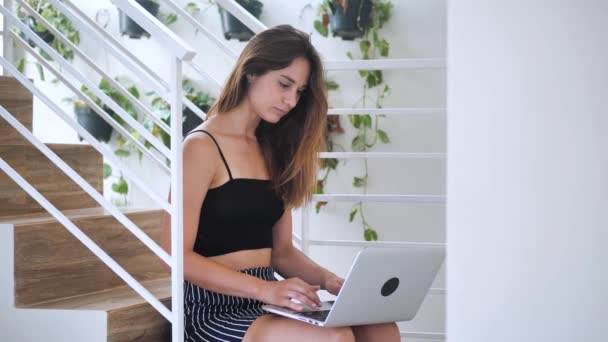 Charismatic beautiful lady working concentrated on her notebook , she sitting on the stairs in the business building 4k — 图库视频影像