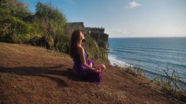 Beautiful and healthy female breathing gently and sits in pose of lotus or sukhasna meditating or practicing yoga and pranayama