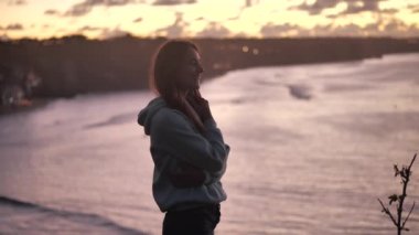 close up portrait of beautiful young woman looking up exploring mindfulness contemplating spirituality with wind blowing hair enjoying peaceful seaside at sunset 4k