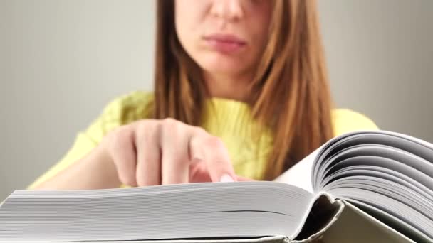 Joven encantadora estudiante leyendo libro tratando de recordar texto 4k — Vídeos de Stock