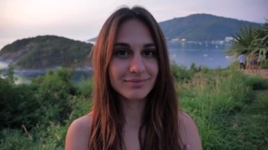 Güzel bir arka planda, çekici bir kadının yakın plan portresi. Dişi, ufuk çizgisine doğru gökyüzüne bakıyor dağın tepesine. Doğada ruhani bir anın tadını çıkarıyor.