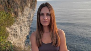 Genç çekici kız gezgin blog yazarının portresi gün batımında dağda yürüyor. 4k