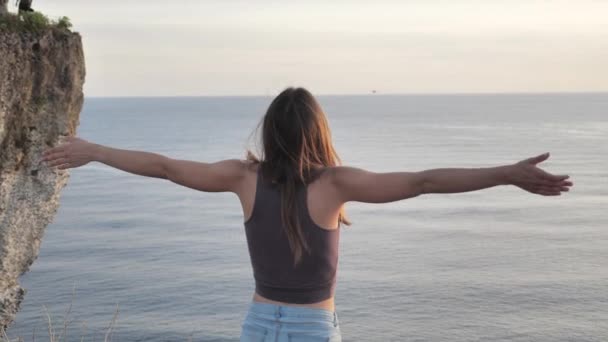 Mooi meisje biddend omhoog kijkend naar oranje lucht met hoop, close-up. Silhouet van jonge vrouw dromen kijken naar boven zonsondergang buiten oceaan achtergrond 4k. — Stockvideo