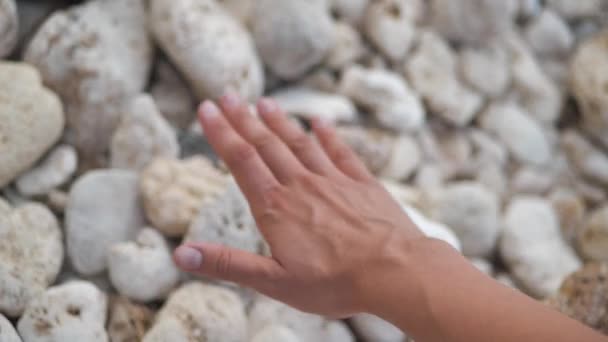 En kvinna håller sin hand på ytan av stenarna på havet. Slappna av 4k — Stockvideo