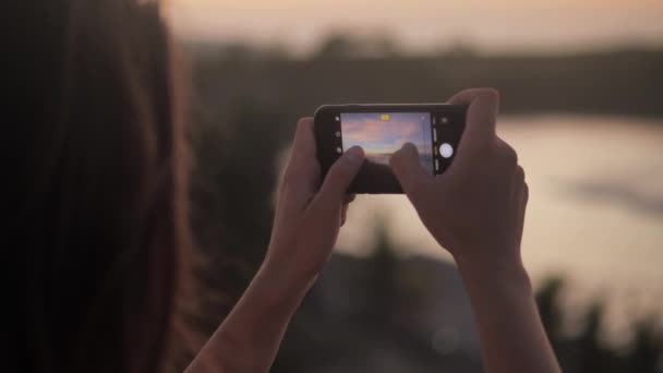 Молодая женщина фотографирует прекрасный вид со смартфона 4k — стоковое видео