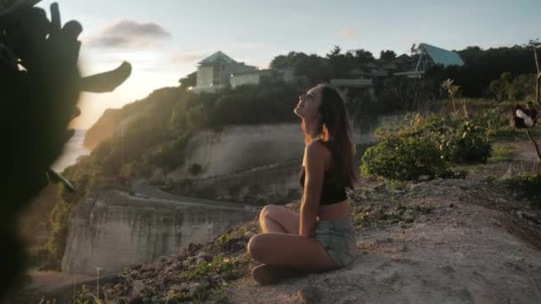 Fille paisible faisant du yoga méditer namaste coucher de soleil côte au ralenti. Bali, Melasti Beach 4k — Video