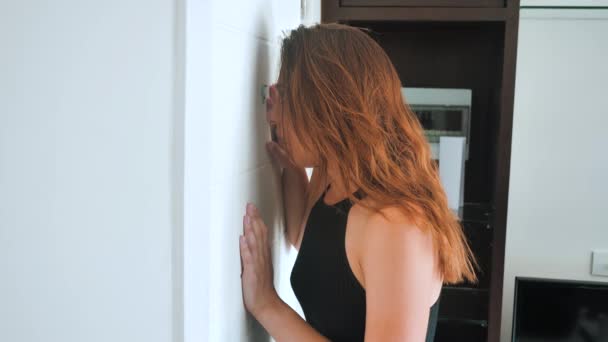 Beautiful woman looking through the peephole of the door. Terrified young woman 4k — Stock Video