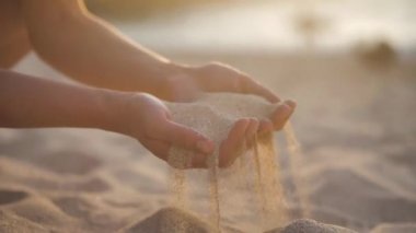 Kumsalda elinde kum tutan bir kadın. 4k