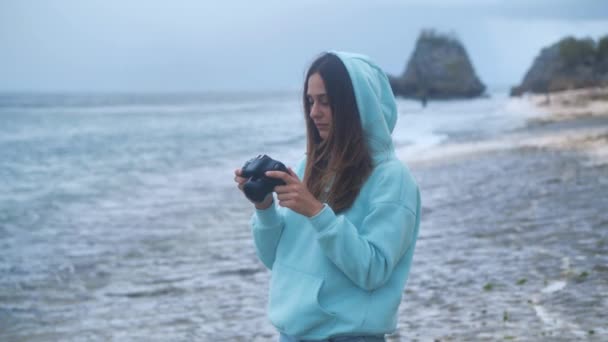 Chica tomar foto video en dslr Mirrorless cámara océano fondo 4k — Vídeos de Stock