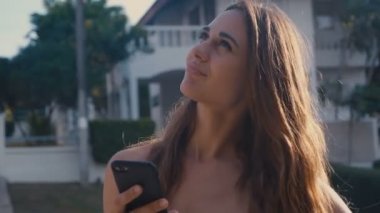 Kameraya bakarken çıplak omuzlarıyla poz veren çekici genç bir kız. Hüküm giydi, hareket etti ve saçını düzeltti.