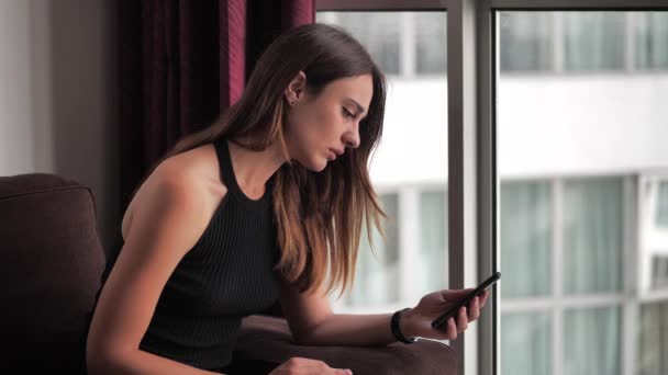 Jolie jeune femme lisant des messages qu'elle pleure. Femme copain gauche via SMS 4k — Video