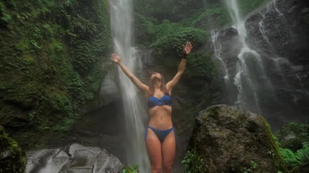 Happy Girl hands up on waterfall background. Sekumpul Waterfall, Bali 4k . — Stock video