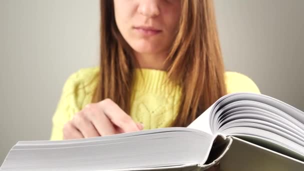 Junge charmante Studentin liest Buch und versucht sich an Text zu erinnern 4k — Stockvideo