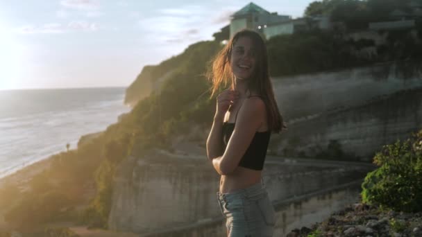 Woman looks at the ocean she is praying. Sunset background. 4k — Stock Video