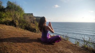 Beautiful and healthy female breathing gently and sits in pose of lotus or sukhasna meditating or practicing yoga and pranayama
