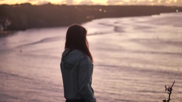 Nahaufnahme Porträt einer schönen jungen Frau, die aufschaut und die Achtsamkeit erforscht, die Spiritualität betrachtet, während der Wind die Haare weht und das friedliche Meer bei Sonnenuntergang genießt 4k — Stockvideo