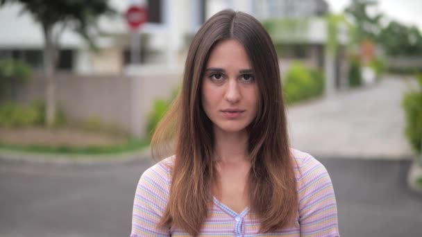 Retrato morena avergonzada baja los ojos y endereza su cabello. 4k — Vídeo de stock