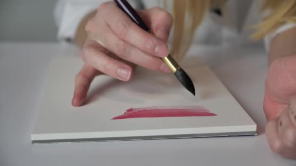 Artists hands paint with a brush on white paper watercolor 4k — Stock Video