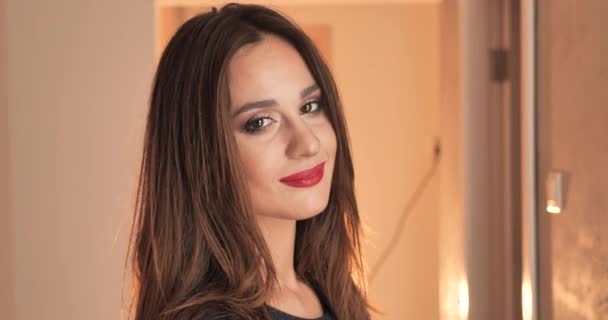 Retrato de hermosa mujer morena con maquillaje de lápiz labial rojo sonriendo a la cámara aislada en el fondo interior, primer plano de la cara 4k — Vídeos de Stock