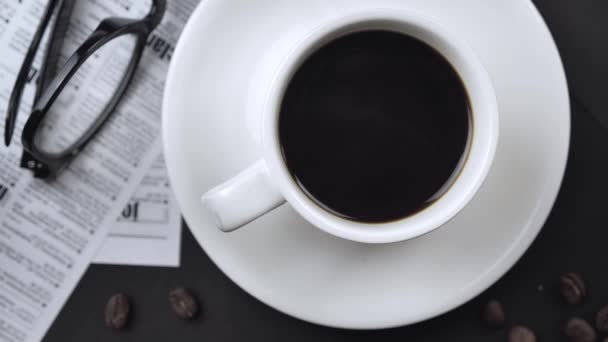 Macho mão direção café em uma xícara na área de trabalho, vista superior câmera lenta 4k — Vídeo de Stock
