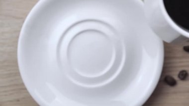Masaüstünde bir fincanda erkek el direksiyonu kahvesi, üstten yavaş çekim 4k.
