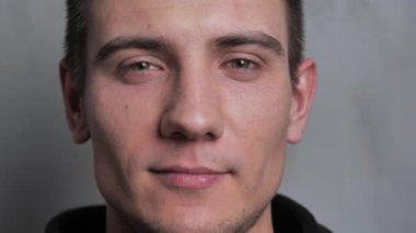 Genç adamların gözlerini kapat ve izole edilmiş beyaz arka plandaki kameraya bak.