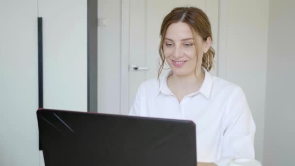 Mosolygó fiatal nő visel headset beszél Skype integető kéz — Stock videók