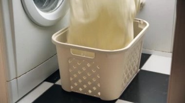 Çamaşır sepetinin içine çamaşır makinesinin yanına kirli çamaşırları atmak.