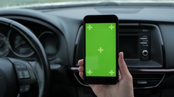 Mujer utiliza un teléfono con un fondo verde sentado en un coche — Vídeos de Stock