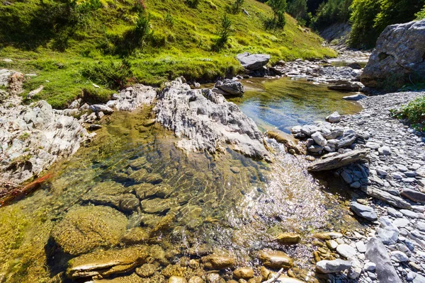 a mountain river with boulders and clear water