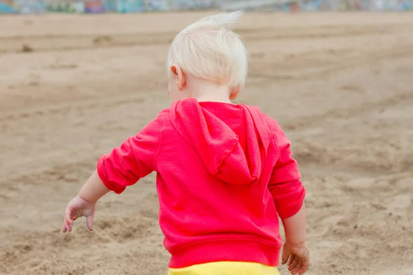 Blont barn promenerar på stranden — Stockfoto