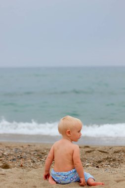 Sarışın bebek sahilde oturma