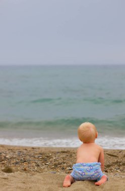 Sarışın bebek sahilde oturma