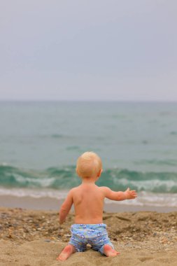 Sarışın bebek sahilde oturma