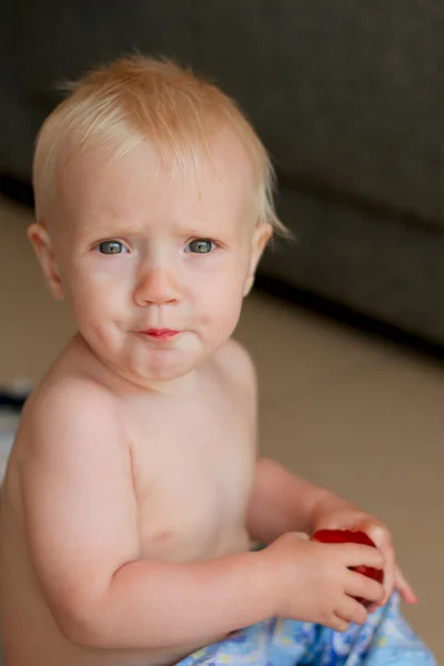 Søt blond baby som spiser en fersken – stockfoto