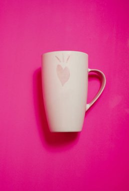 Sevgililer Günü hediyesi, pembe kalpli beyaz kupa ve pembe arka plan.