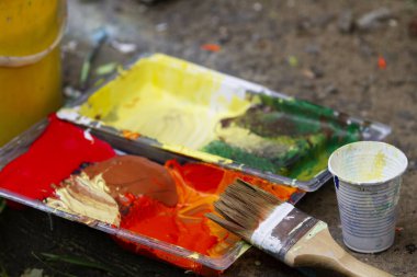 Açık havada boyama: Boya, boya fırçası ve kaldırımdaki diğer boya aletleri
