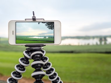 Smartphone take a landscape photo on tripod clipart