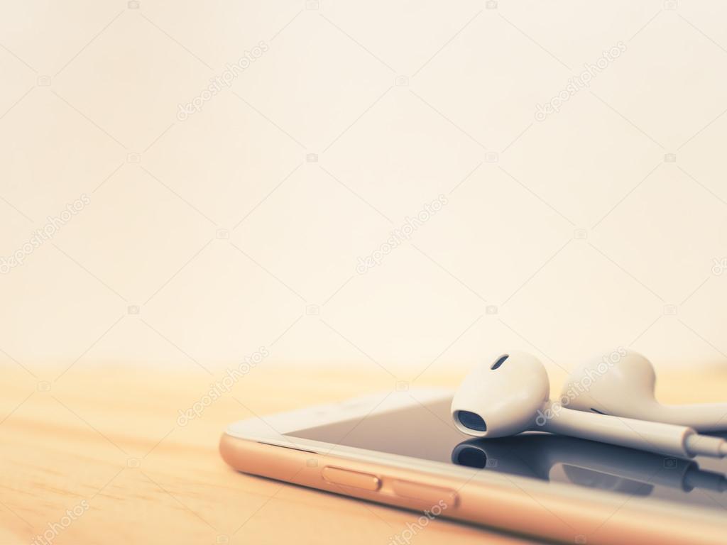 Earbuds on top of smartphone and reflection