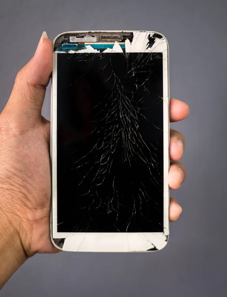 Menschliche Hand hält kaputtes Bildschirm-Smartphone — Stockfoto