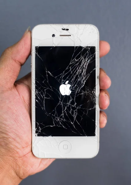 Mão humana segurando quebrado Apple iPhone smartphone — Fotografia de Stock
