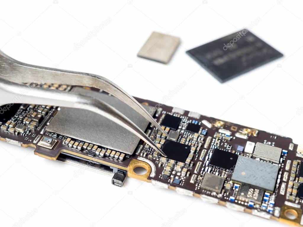 Technician replacing microchip of smartphone logic board 