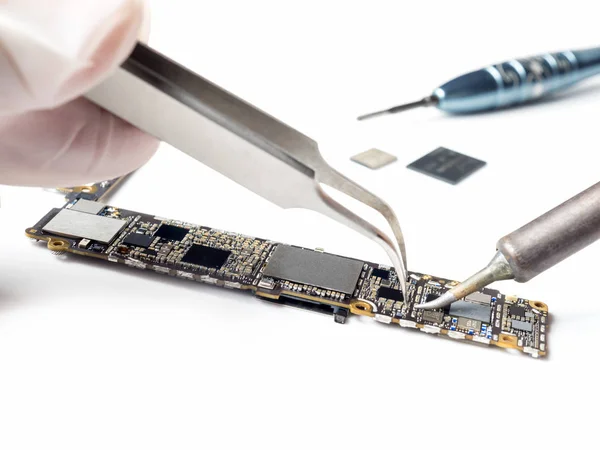 Técnico reemplazando el microchip de la placa lógica del teléfono inteligente — Foto de Stock