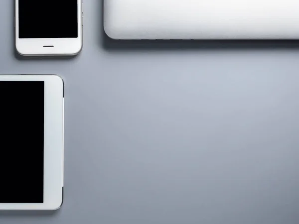 Ordenador portátil, smartphone y tableta sobre fondo gris —  Fotos de Stock