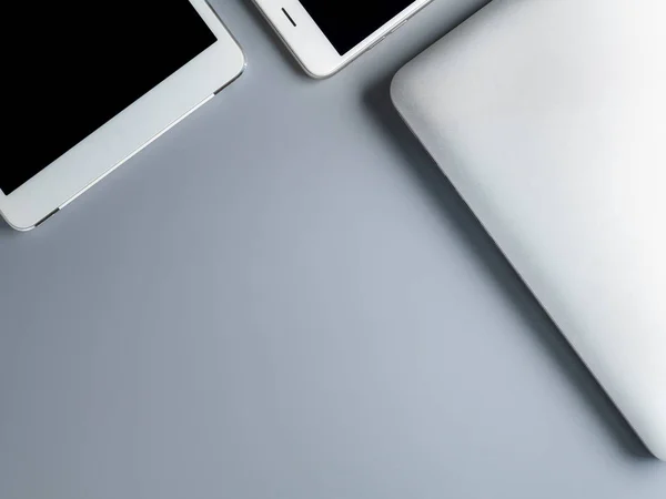 Laptop, smartphone e tablet em fundo cinza — Fotografia de Stock
