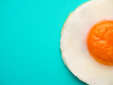 Mavi-yeşil arka planda mükemmel bir kızarmış yumurta.