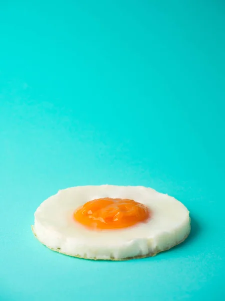 Telur goreng lingkaran sempurna dengan latar belakang biru-hijau — Stok Foto