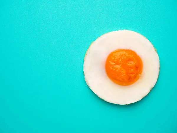 Telur goreng lingkaran sempurna dengan latar belakang biru-hijau — Stok Foto