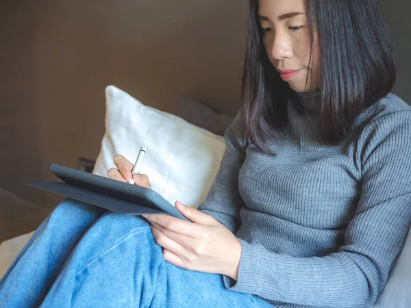 Asyalı Sıradan Giyinen Güzel Bir Kadın Bluetooth Kalemle Tablet Kullanıyor — Stok fotoğraf