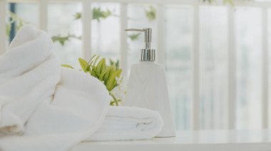 Şampuan ve duş kremi şişesi. Banyoda beyaz havlu ve fotokopi alanı var..